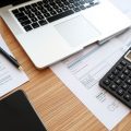 Birou cu laptop și documente financiare pentru afaceri.